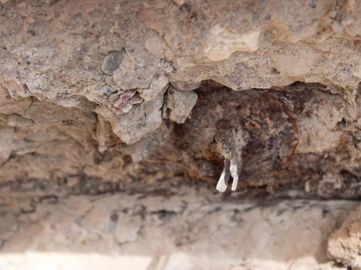 Heavily corroded post-tension anchor and tendon end inside a concrete slab